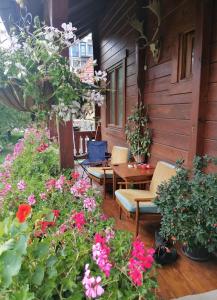 un porche con flores, mesa y sillas en Dana apartmani, en Kolašin