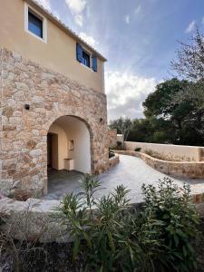 利勒魯斯的住宿－Casa u fornu Residence & Spa，前面有拱门的石头建筑