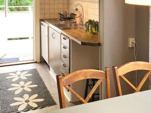 cocina con fregadero y encimera con 2 sillas en Holiday home STILLINGSÖN V, en Stillingsön