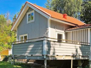 una casa con un gran porche con techo naranja en Holiday home STILLINGSÖN V, en Stillingsön