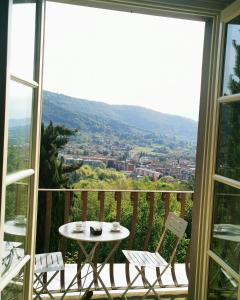 uma mesa e cadeiras numa varanda com vista em B&B Dimora Delle Donnole Bergamo Alta em Bérgamo