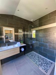 a bathroom with a tub and a sink and a shower at Casa u fornu Residence & Spa in LʼÎle-Rousse