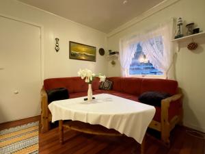 sala de estar con mesa y sofá rojo en Fishermans Rorbu 2 - Lofoten, en Ramberg