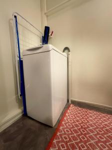 frigorifero bianco in camera con tappeto rosso di Fishermans Rorbu 2 - Lofoten a Ramberg