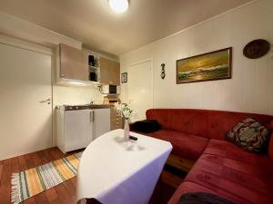un soggiorno con divano rosso e tavolo bianco di Fishermans Rorbu 2 - Lofoten a Ramberg