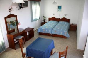 a bedroom with a bed and a table and a desk at Naxos Edem Studios & Apartments in Naxos Chora