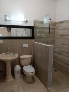 een badkamer met een toilet en een wastafel bij El Mirador Holbox in Holbox Island