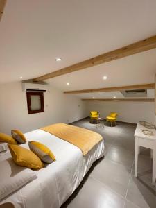 ein Schlafzimmer mit einem großen Bett und zwei gelben Stühlen in der Unterkunft La Listrella Residence & Spa in Monticello