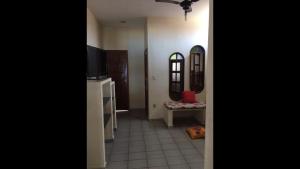 a hallway with a kitchen and a living room with a tv at Casa Temporada Frente à Praia Piscina Ar cond Nova Viçosa VA in Nova Viçosa +4 photos