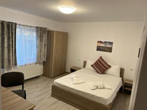 a bedroom with a bed with two towels on it at Vila Palade in Corbu