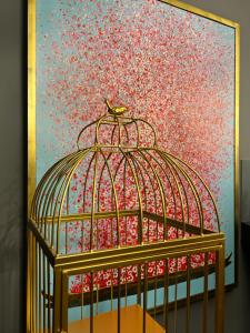 une peinture d'un oiseau dans une cage pour oiseaux dans l'établissement Allee Hotel, à Karlsruhe