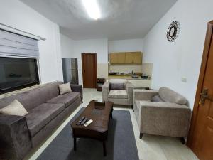 a living room with two couches and a table at Cozy Home 2 in Amman