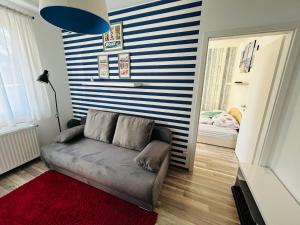a couch in a living room with a striped wall at CAC Wellness Apartment in Siófok