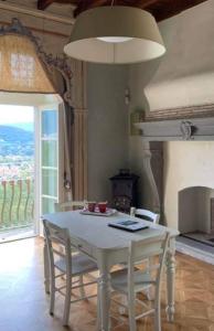- une table et des chaises blanches dans une pièce avec cheminée dans l'établissement B&B Dimora Delle Donnole Bergamo Alta, à Bergame