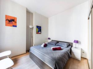 een slaapkamer met een bed en een witte muur bij Le Saboly in Avignon