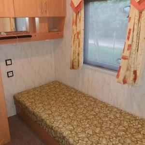 Cama pequeña en habitación con ventana en Ubytování v klidné lokalitě, en Trutnov
