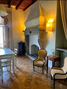 sala de estar con chimenea, mesa y sillas en B&B Dimora Delle Donnole Bergamo Alta, en Bérgamo