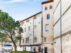 een oud gebouw met een boom ervoor bij Le Saboly in Avignon