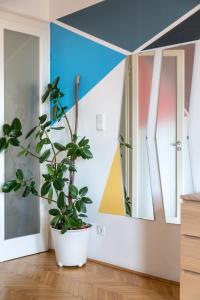 Zimmer mit Topfpflanze und zwei Spiegeln in der Unterkunft Art Downtown Home styled by a Local Designer in Budapest