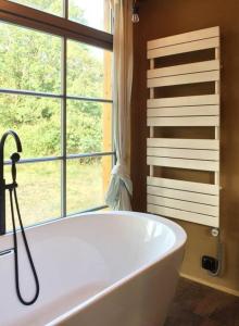 a bath tub in a bathroom with a window at Tiny Haus auf idyllischem Grundstück im Rittergut in Klipphausen