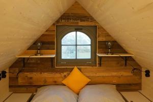 Bett in einem Zimmer mit Fenster in der Unterkunft Tiny Haus auf idyllischem Grundstück im Rittergut in Klipphausen