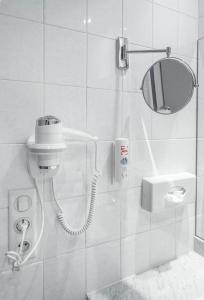 bagno con doccia, specchio e telefono. di Hotel Chris'tel a Le Puy en Velay