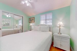 Schlafzimmer mit einem weißen Bett und einem Spiegel in der Unterkunft Duval Hideaway in Key West