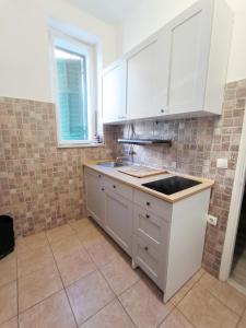 a kitchen with white cabinets and a sink at Apartment Sole Macula in Split