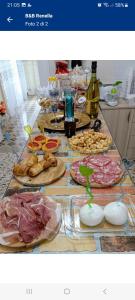 una mesa con muchos platos de comida y botellas de vino en B&B Renella, en Caserta