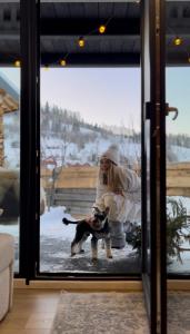 a woman sitting in front of a door with a dog at UGRAD family in Slavske