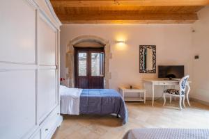 a bedroom with a bed and a desk and a mirror at Agriturismo Kypeiros in Noto +88 photos