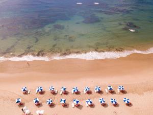 uma vista sobre uma praia com cadeiras e guarda-sóis em Bahia Plaza Hotel em Busca-Vida