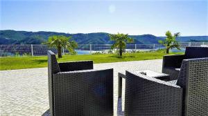 un gruppo di sedie di vimini seduti su un patio di Lago Azul Villas a Ferreira do Zêzere