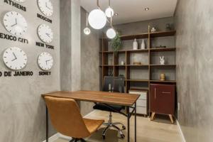 an office with a desk and clocks on the wall at ZEE Studios by Viva - Studios a 200m da beira-mar norte in Florianópolis