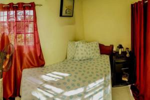 a small bedroom with a bed and red curtains at Apartamento en la Romana in La Romana