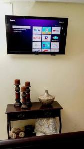 a television hanging on a wall above a table at Apartamento en la Romana in La Romana