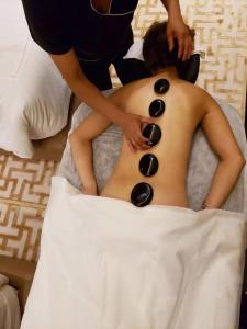 a woman laying on a bed with a face drawn on her stomach at Hotel Temático Casa Puebla in Puebla