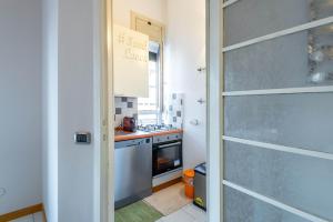 a small kitchen with a stove and a door at Easylife - Spazioso e accogliente bilocale in zona Lambrate in Milan