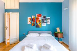 a blue bedroom with a bed with two white pillows at Easylife - Spazioso e accogliente bilocale in zona Lambrate in Milan
