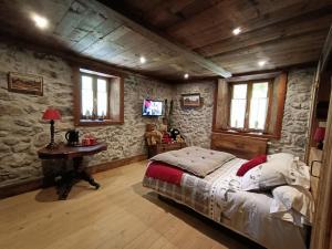 a bedroom with a bed and a table and windows at Les Sapins Blancs in Vacheresse