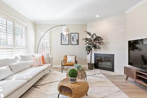 a living room with a white couch and a fireplace at @ Marbella Lane - Modern Refreshing Home in San Mateo