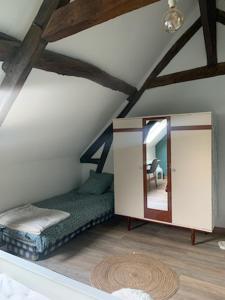 a room with a bed and a mirror in a attic at La Bretonnière, Longère Picarde in Passel