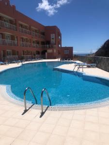 una grande piscina di fronte a un edificio di Beach front apartment with stunning ocean views! a Costa Calma