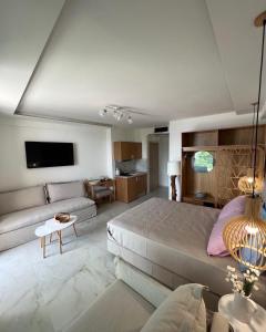 a large bedroom with a bed and a couch at Wide Blue Luxury Boutique Suites in Neos Marmaras