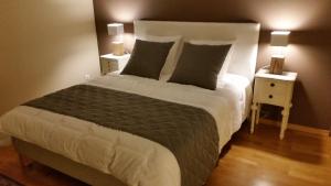 una camera da letto con un grande letto con due comodini di La Chouette Maison - Chambres d'hôtes et Gîte en Ville a Remiremont