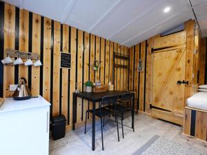 a room with a table and chairs and a wooden wall at Woodshed Pod in Fort William