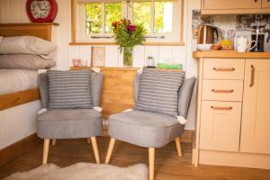 two chairs in a tiny kitchen with a bed at Harrys Hideout - Shepherd's Huts at Harrys Cottages in Pen y Clawdd