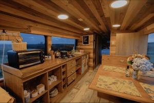 una gran cocina con paredes de madera y techos con ventanas. en Bus Casa en observatorio de aves en Puerto Montt