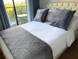 a bed with two pillows on it with a window at Ness Haven Camella northpoint condominium in Davao City