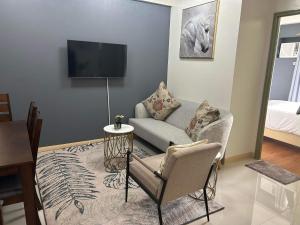 ein Wohnzimmer mit einem Sofa und einem TV in der Unterkunft Ness Haven Camella northpoint condominium in Davao City